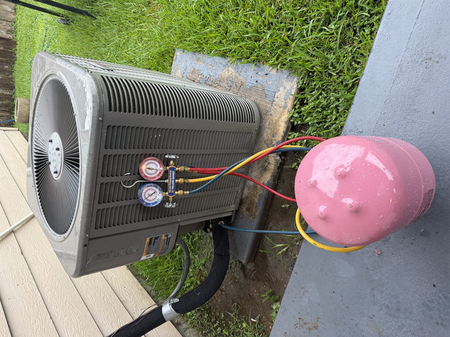 Sorto Services technician charging an outdoor A/C condenser unit in Houston
